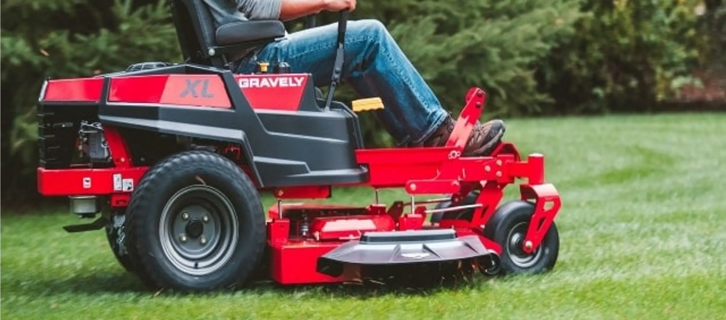 worker mowing lawn with a profesional mower